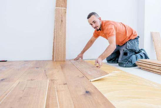 Renovierungkosten: Mann verlegt Holzboden