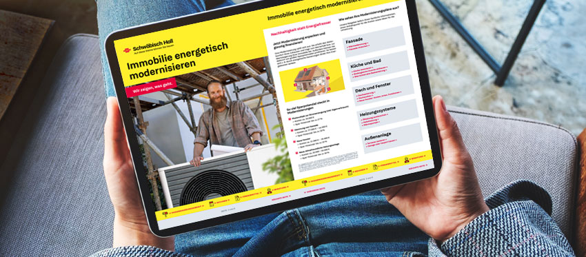 Sitzende Person hält ein Tablet in der Hand