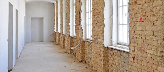 Unverputzte Fensterfront mit Leerrohren im Innenbereich