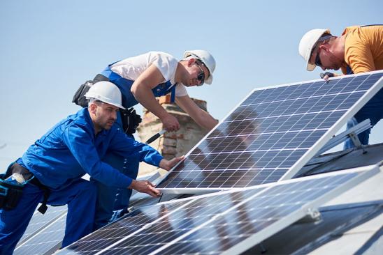 Handwerker installieren PV-Module.