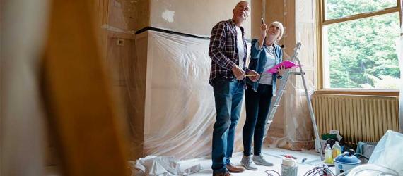 Paar steht in einem Haus, das gerade saniert wird