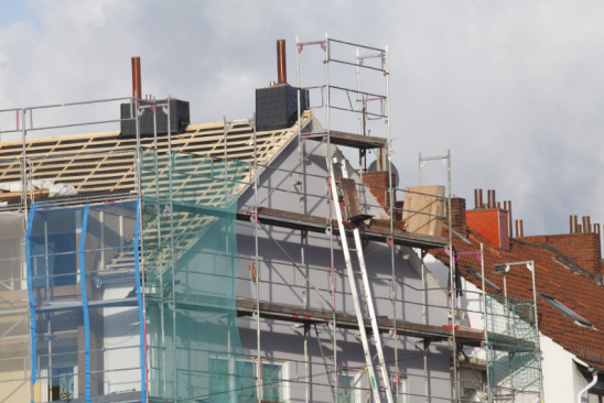 Eingerüstetes Haus mit nicht gedecktem Dach