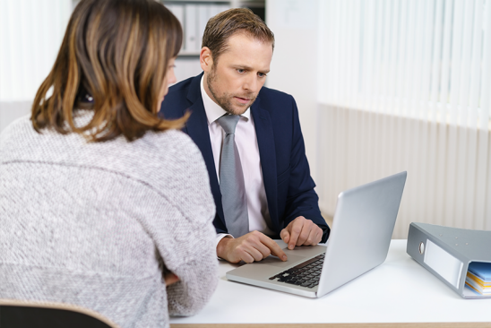 Mann und Frau sitzen am Schreibtisch