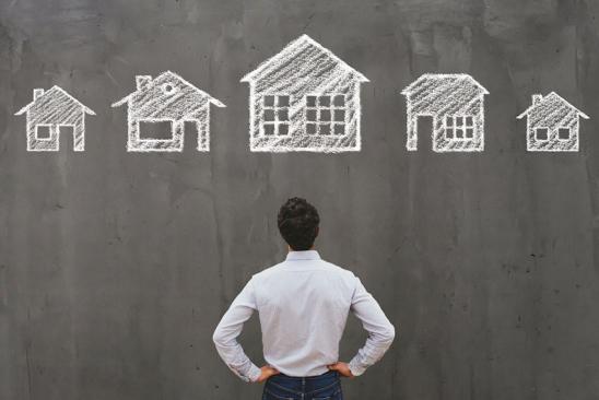 Mann vor dunkler Wand mit gezeichneten Häusern