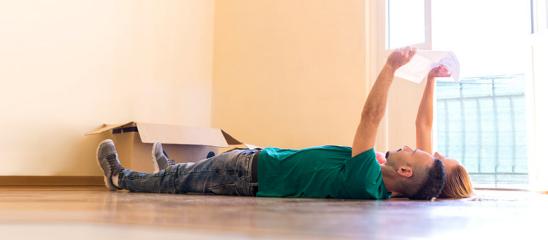 Junges Paar liegt in frisch bezogener Immobilie