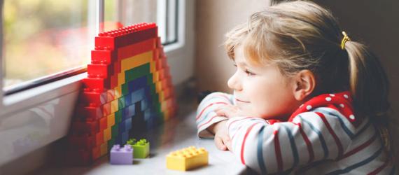 Bausparvertrag verschenken: Kind schaut aus dem Fenster