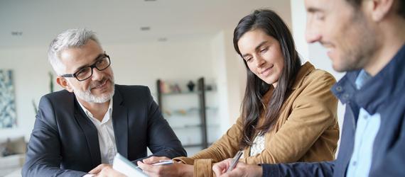 Berater informriert Paar in Beratungsgespräch.