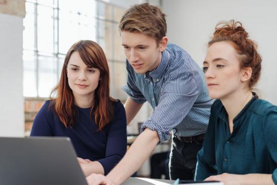 Drei junge Leute vor dem PC