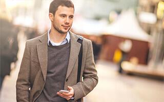 Bausparen Informationsmaterial anfordern - junger Mann mit Smartphone