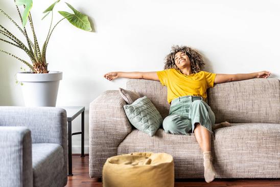 Glückliche Frau sitzt auf Sofa
