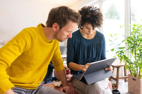 Paar sitzt gemeinsam am Tablet