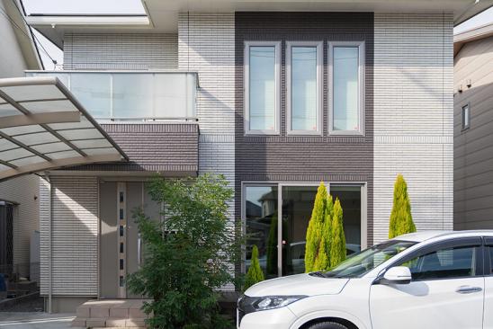 Auto parkt vor Einfamilienhaus.
