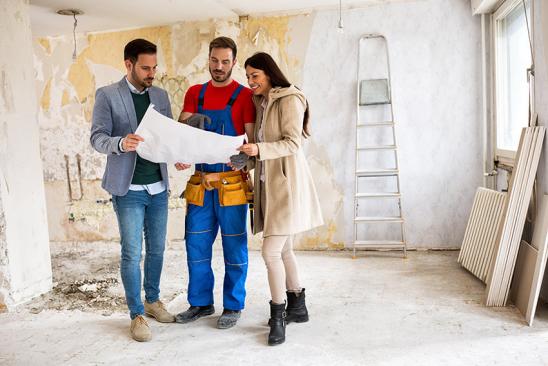 Paar prüft mit Handwerker Bauplan