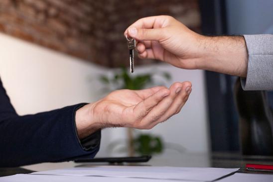 Makler übergibt Hausschlüssel an Eigemtümer