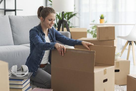 Junge Frau packt Umzugskiste