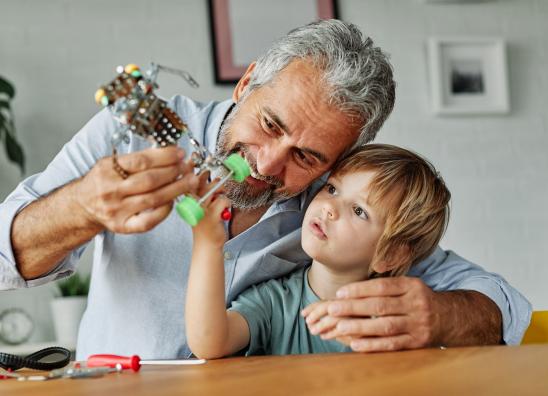 Großvater repariert mit seinem Enkel den Rollschuh.