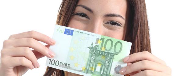 100 Euro Bausparvertrag: Junge Frau hält 100-Euro-Schein vor dem Gesicht