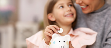 Tochter und Mutter werfen Geld in das Sparschwein