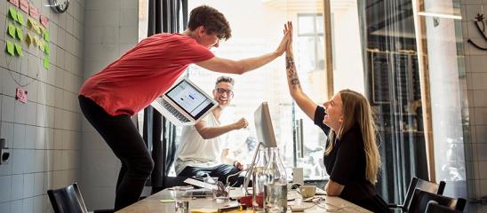 Junger Mann und junge Frau geben sich high five.