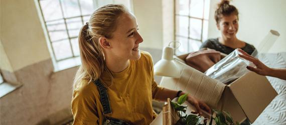 Zwei junge Frauen mit Umzugskarton