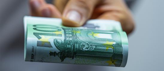 Hand hält zusammengeklappten 100-Euro-Schein