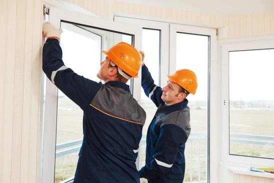 Zwei Handwerker bauen ein Fenster ein