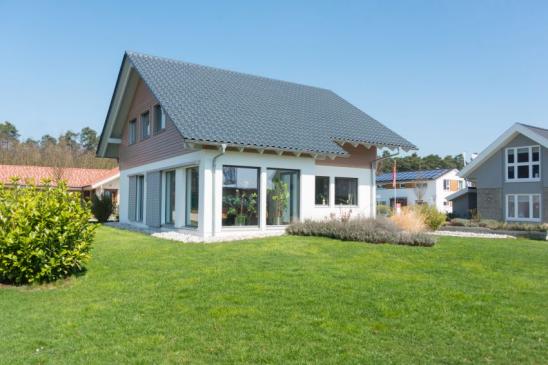 Einfamilienhaus mit großen Fenstern und großem Garten