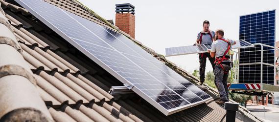 Fachleute montieren Solarmodule aufs Dach