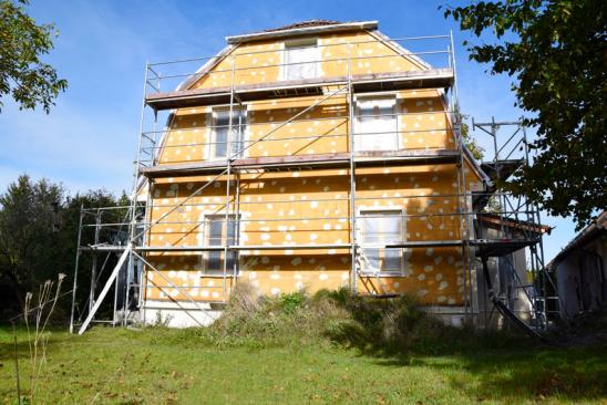 Energetische Sanierung: Grundlagen und Pflichten Eingerüstete, gedämmte Hausfront