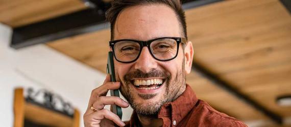 Anschlussfinanzierung: Gut gelaunter Mann am Handy