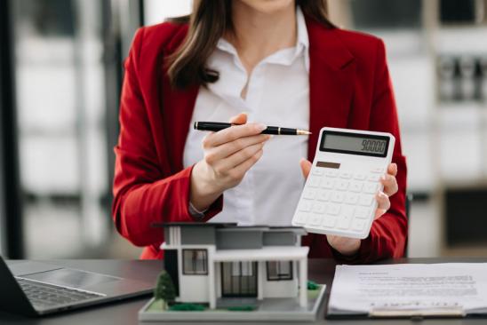 Prolongation: Frau hält Taschenrechner frontal zur Ansicht