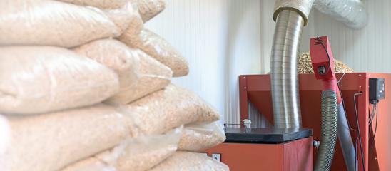 Pelletheizung mit Pelletsäcken im Vordergrund