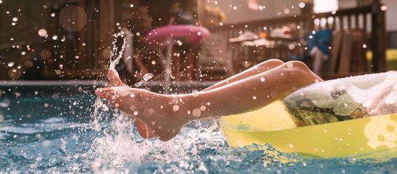 Kinderbeine beim Plantschen im Pool