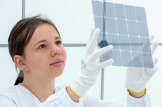 Junge Frau betrachtet Solarmodul