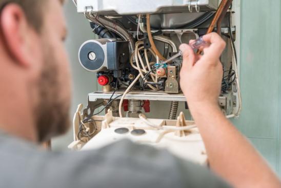 Technician repairing Gas Furnace.