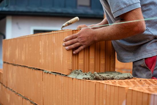 Arbeiter auf einer Baustelle beim Bau einer Mauer