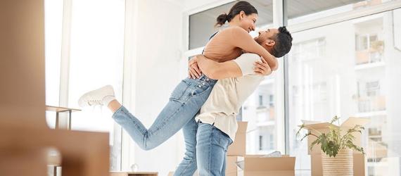Eigentumswohnung finanzieren: Junges Paar freut sich über den Einzug
