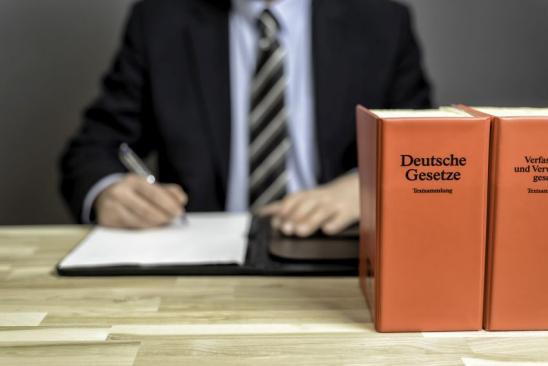 Mann am Schreibtisch mit Gesetzesbücher