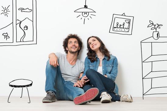 Junges Paar auf dem Boden sitzend vor Wand mit Skizzen