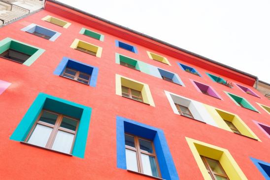 Mehrstöckiges Stadthaus mit verschiedenfarbigen Fenstereinfassungen