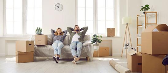 Mietkauf: Frisch eingezogenes Paar sitzt auf der Couch