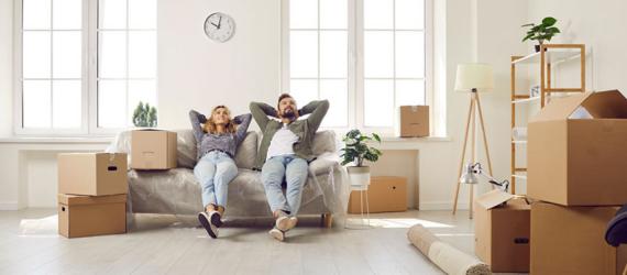 Mietkauf: Frisch eingezogenes Paar sitzt auf der Couch