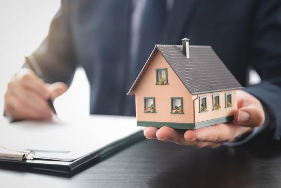 Modellhäuschen auf linker Handfläche gehalten