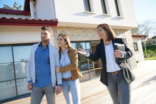 Couple with real-estate agent visiting house for sale
