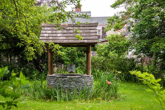 Klassischer Brunnen im grünen Garten
