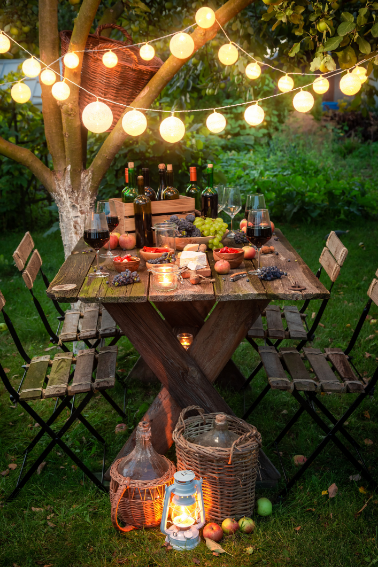 Abendessen mit Wein im beleuchteten Sommergarten
