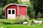 Rotes Gartenhaus mit weißer Türe und Runddach