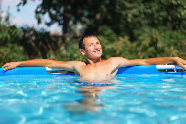Mann im Pool genießt die Sonne