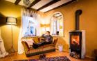 Bauernhaus renovieren - Thomas M. Held auf Sofa vor Kaminofen