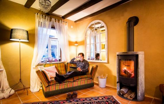 Bauernhaus renovieren - Thomas M. Held auf Sofa vor Kaminofen
